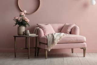 pink country style armchair against a pink wall with pale wooden flooring